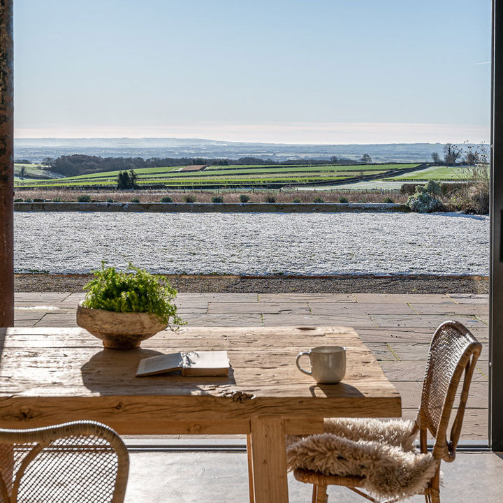 Hand Crafted Salvaged Dining Table in front of a snowy landscape