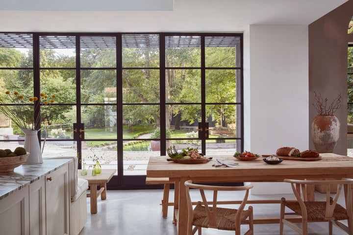 Hand Crafted Salvaged Dining Table in front of crittal windows with garden view