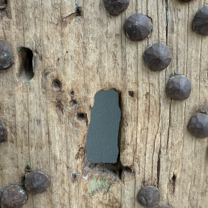 Close-up of wooden surface with metal nails and a large nail hole.