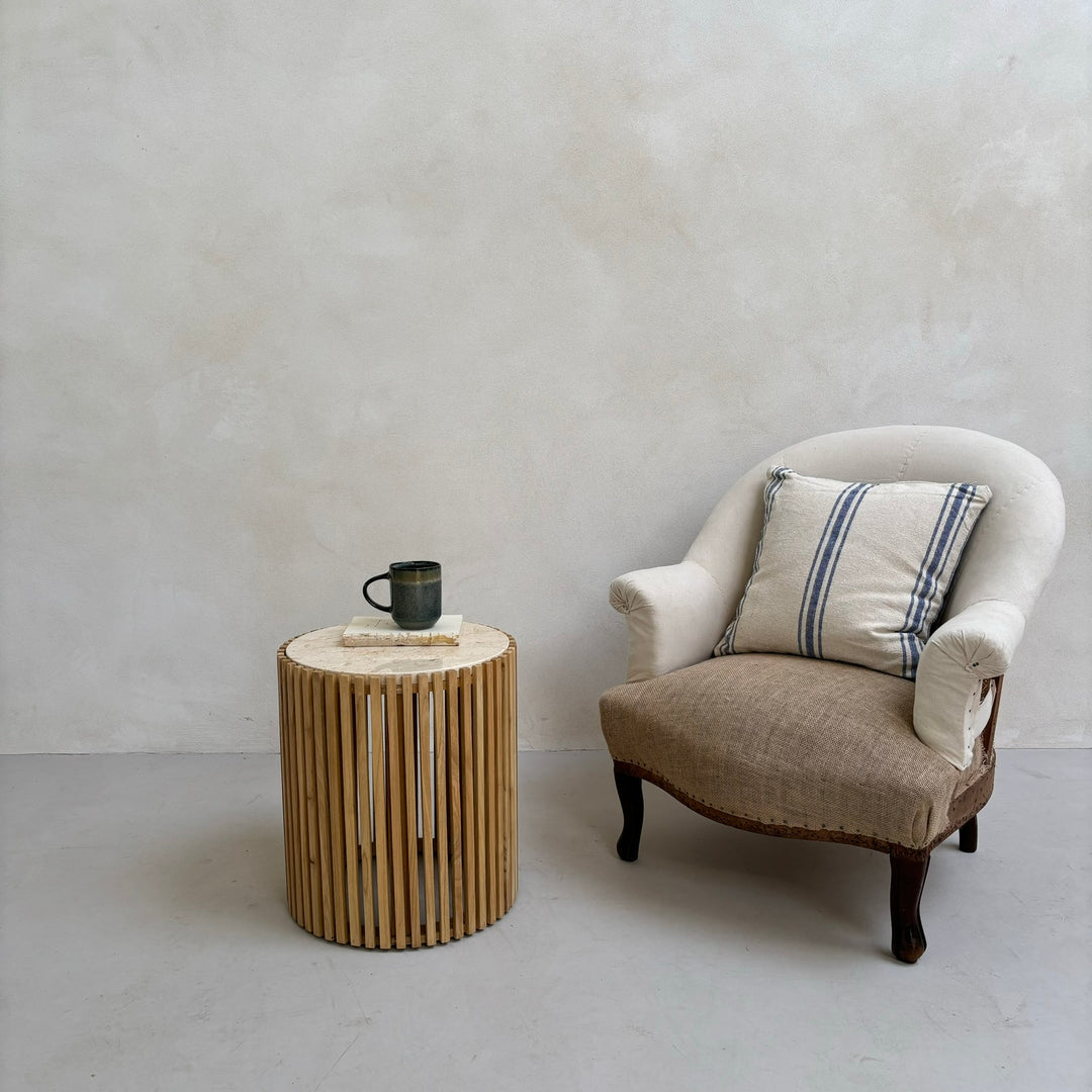 Slatted round marble topped side table next to a chair