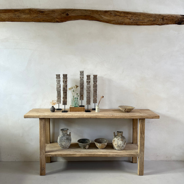 Vintage Balinese wooden statue on stand group on a console table in a barn