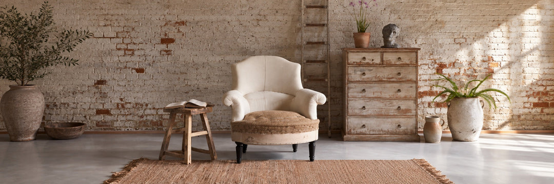 an deconstructed French antique armchair displayed next to a Home Barn rustic antique coffee table in a light and bright modern rustic home