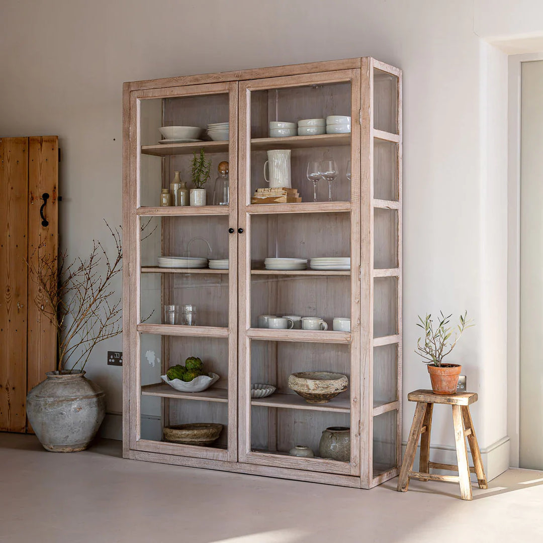 a pale reclaimed wood glass shelving unit displaying a selection of modern rustic ceramics and glassware