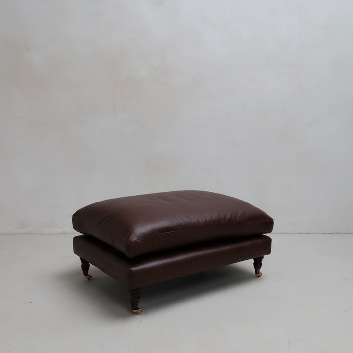 Brown leather ottoman on a white background
