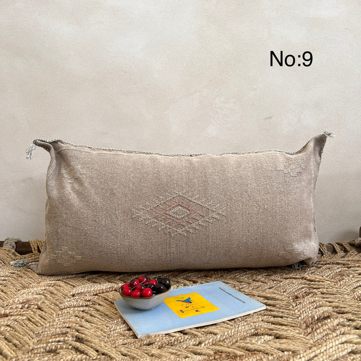 Cacus silk cushion - Beige rectangular pillow with a geometric pattern on a textured surface.