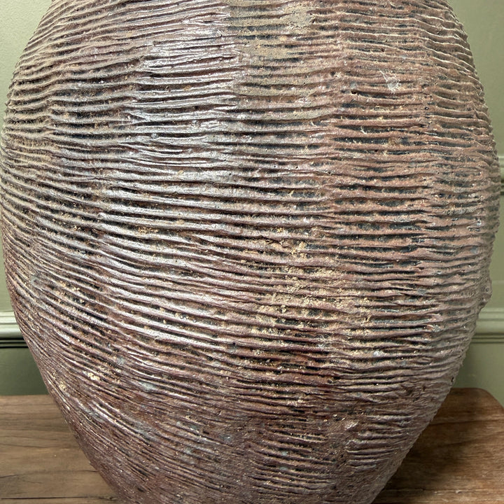 Detailed view of the distinctive hand-combed texture on an antique Chinese stoneware storage jar, highlighting its artisan craftsmanship and aged patina.
