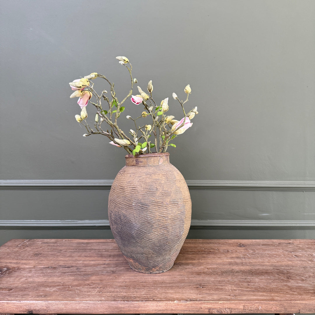 An authentic antique Chinese stoneware storage jar in a contemporary country home, highlighting its unique texture and historic patina
