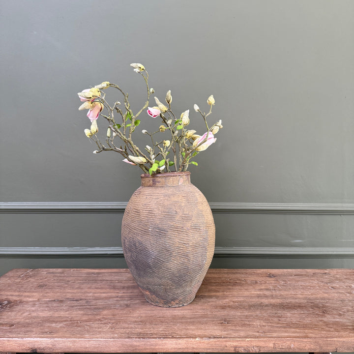 An authentic antique Chinese stoneware storage jar in a contemporary country home, highlighting its unique texture and historic patina