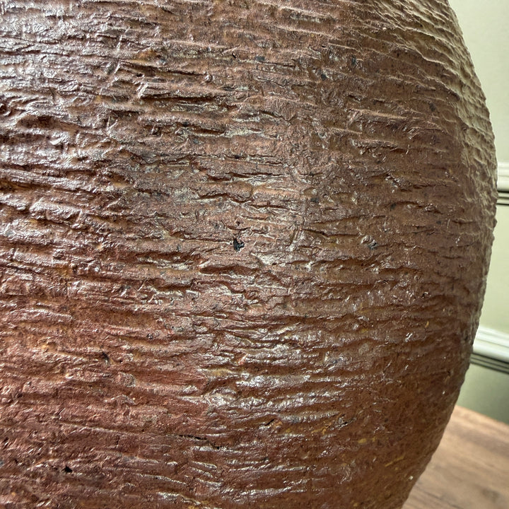 Close-up of the rich earthy patina and naturally weathered finish on an authentic antique Chinese stoneware storage jar.
