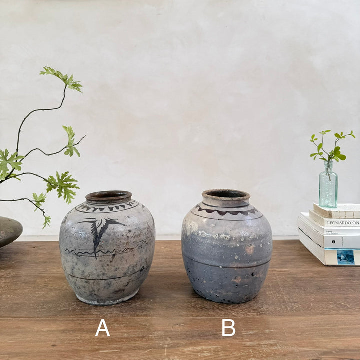 Two authentic Ming Dynasty pottery storage jars illustrating the unique hand-painted decoration and historic character of each antique.
