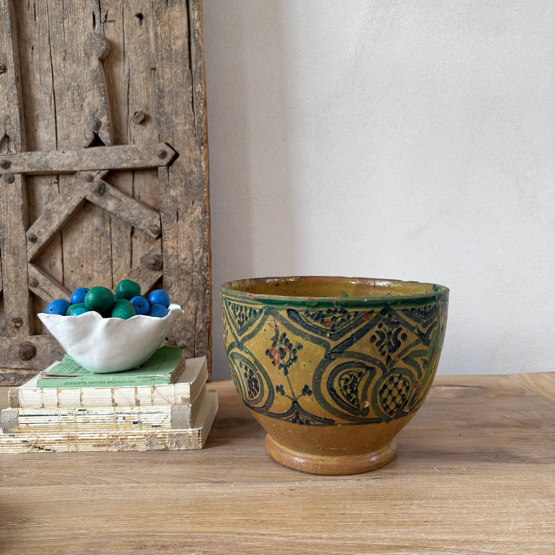 Decorative ceramic bowl with intricate patterns on a wooden surface.