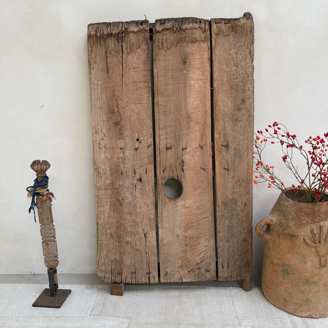 Vintage wooden cabinet with a decorative plant and sculpture on a light background