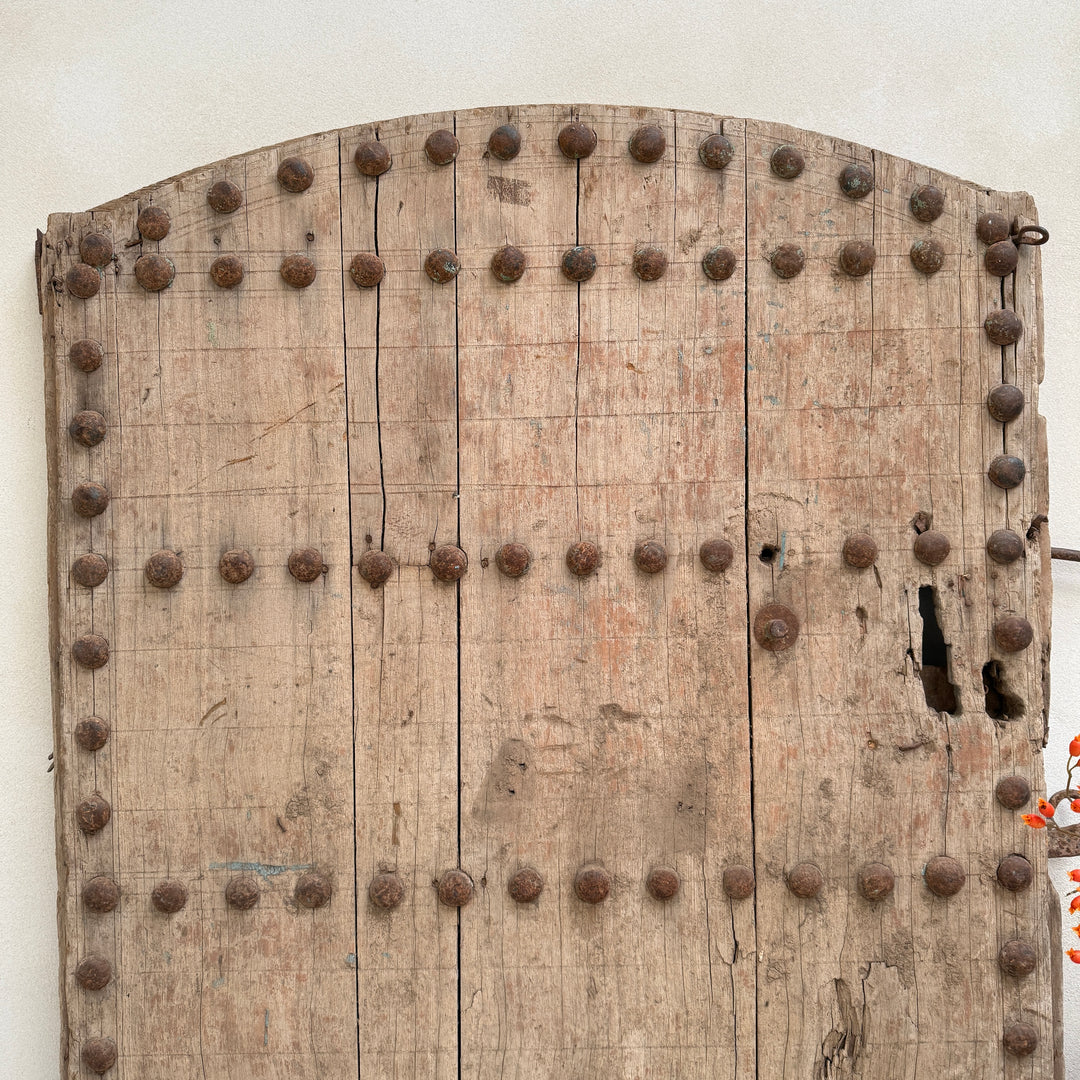 Wooden door with metal studs on a white background