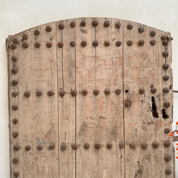 Wooden door with metal studs on a white background