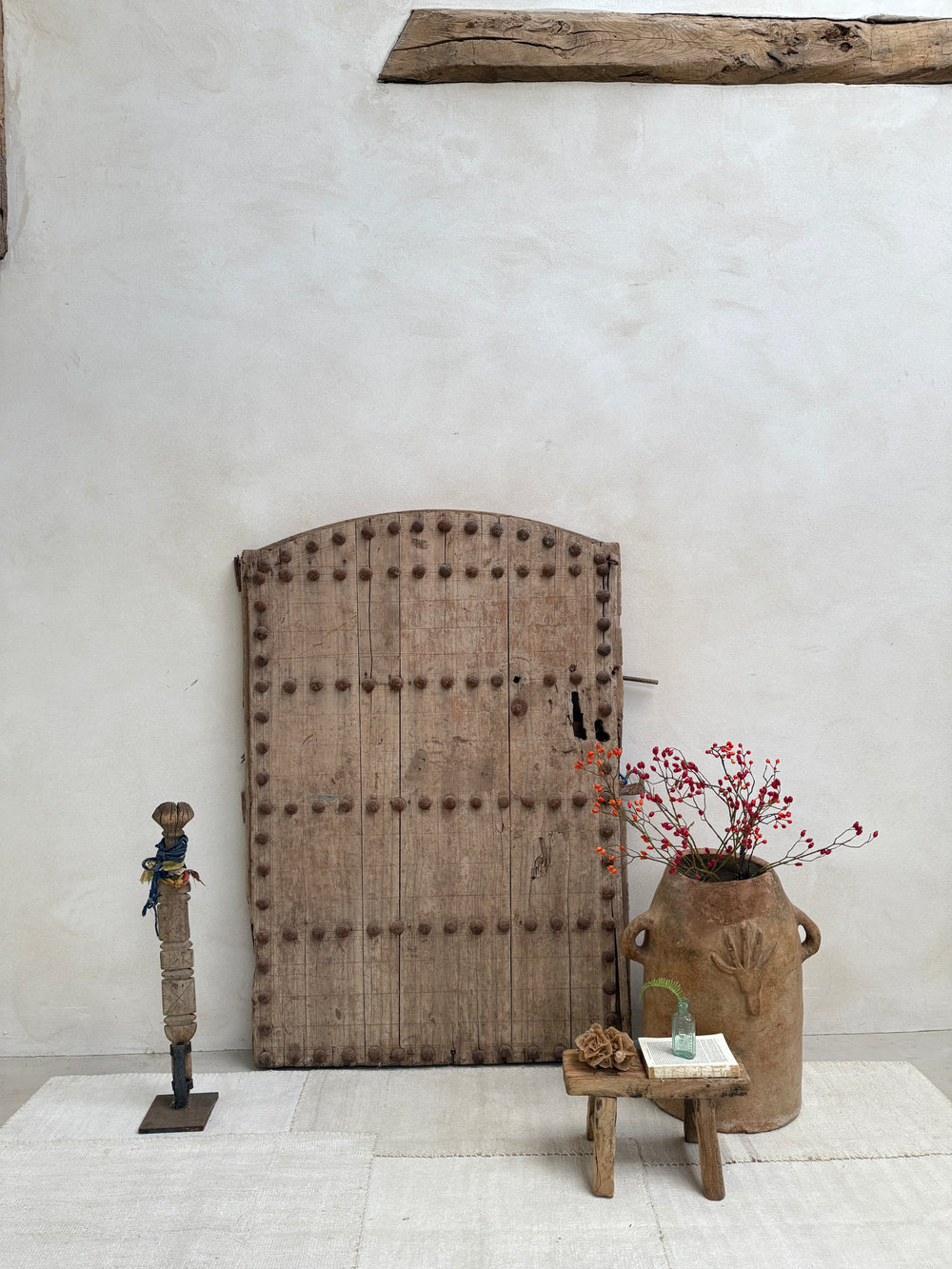 Rustic wooden shelf against a white wall with decorative items.