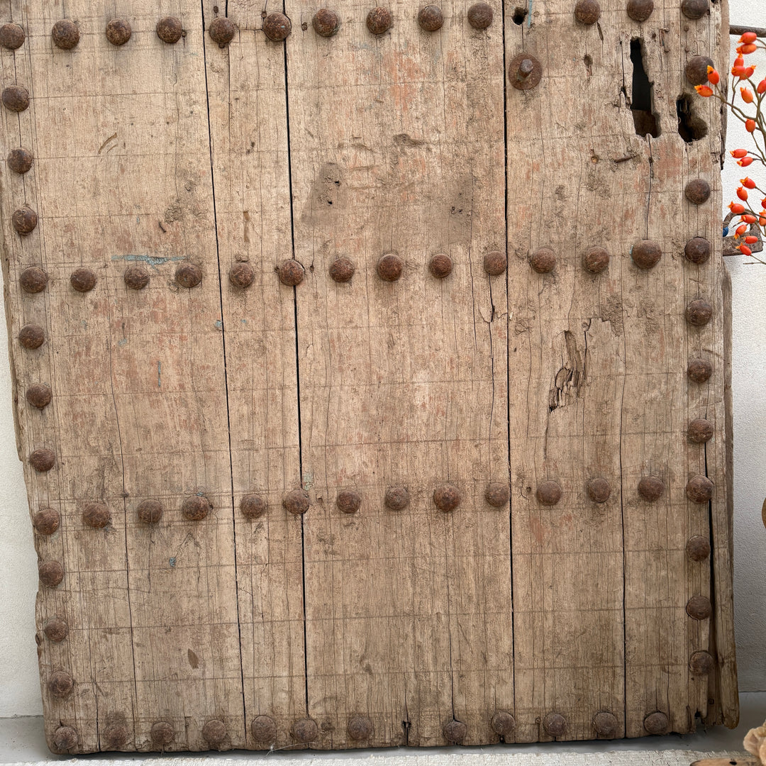 Vintage wooden door with metal studs on a white background
