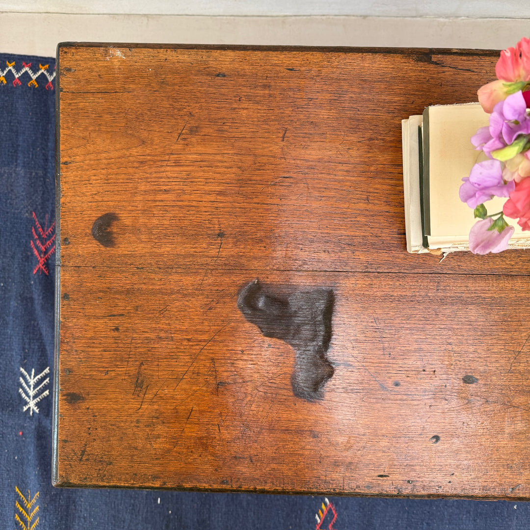 Close-up of the historic burn mark on the solid oak lid, forming part of the authentic character and history of this Victorian blanket box.
