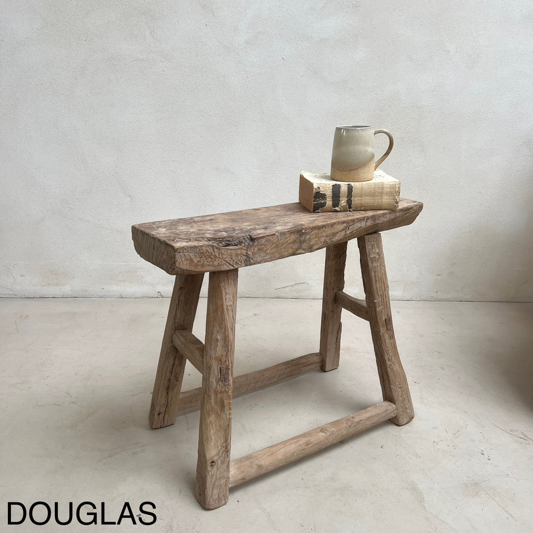 Wooden stool with a mug and book on a plain background, featuring the brand &