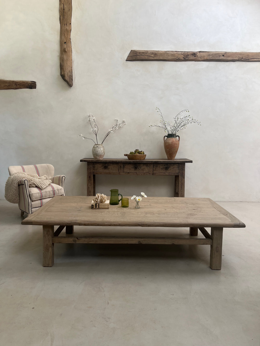Wooden furniture against a plain wall with decorative elements.
