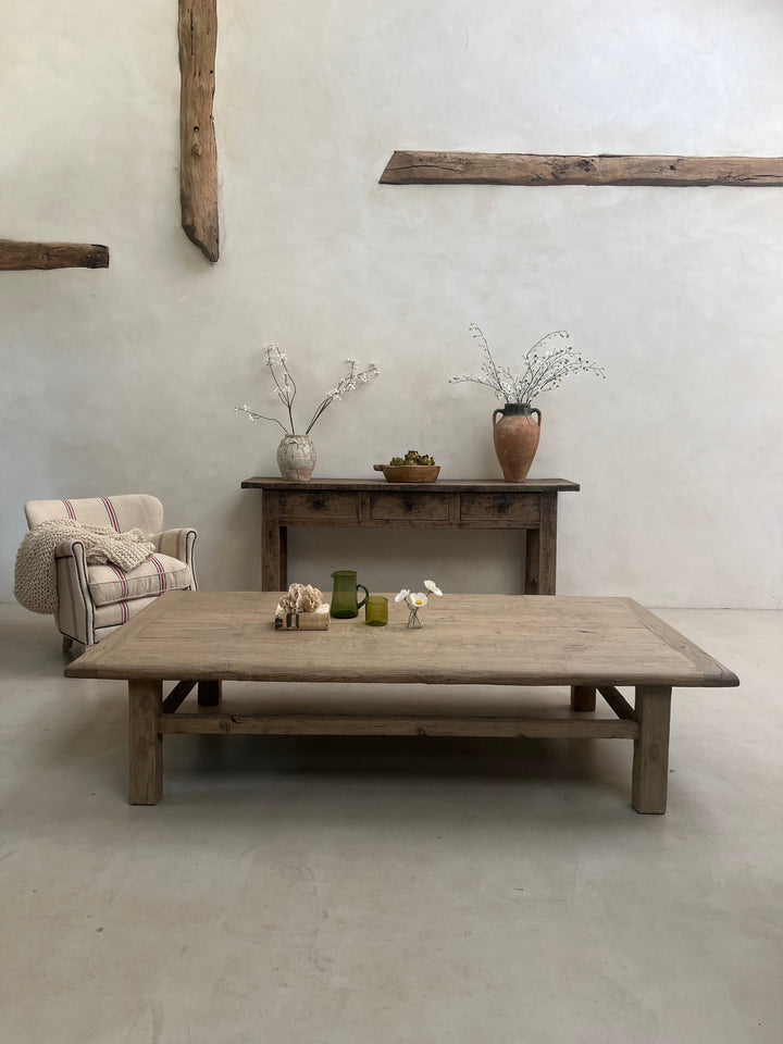 Wooden furniture against a plain wall with decorative elements.