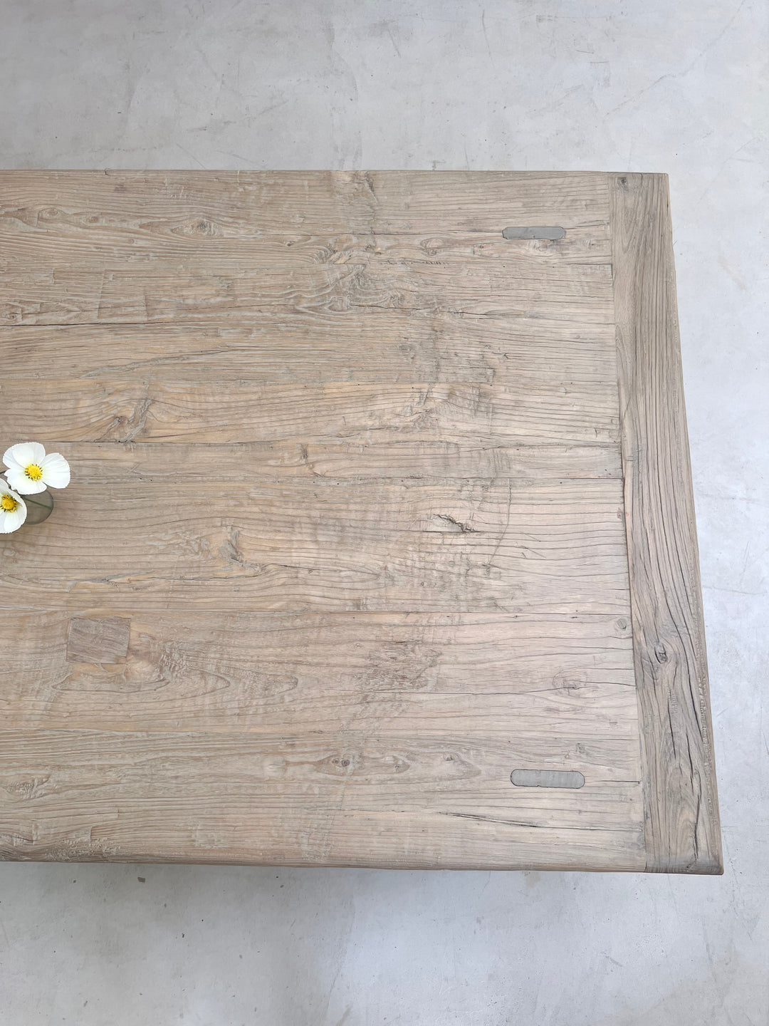 Wooden cutting board with a floral arrangement on a gray surface