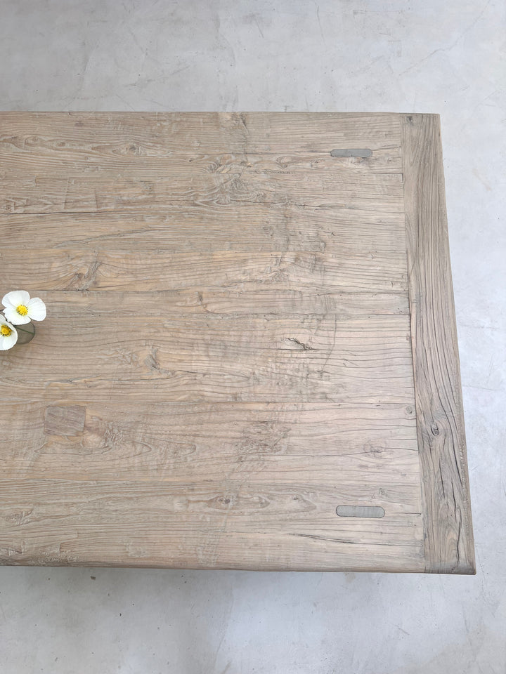 Wooden cutting board with a floral arrangement on a gray surface