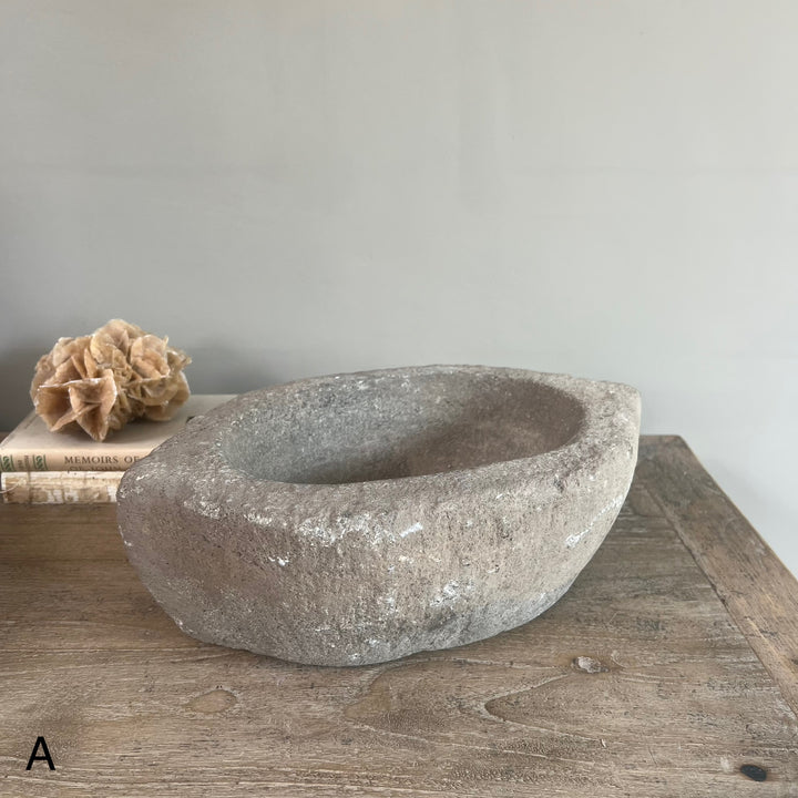Stone basin on a wooden surface with a neutral background