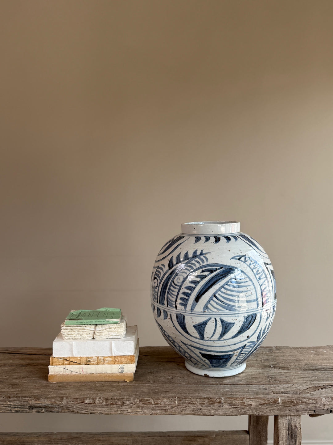 Blue and white porcelain vase displayed on a reclaimed wooden console, highlighting its timeless silhouette and hand-painted decorative detailing.
