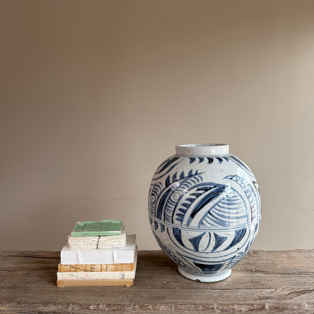 Side view of a hand-painted blue and white porcelain vase with traditional Chinese-inspired botanical decoration and an authentic artisan finish.
