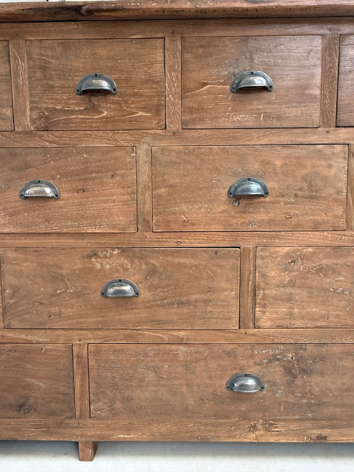 Detailed view of the Chiswick apothecary-style chest highlighting the individually sized drawer fronts, traditional cup handles and handcrafted solid teak construction that define its distinctive architectural character.