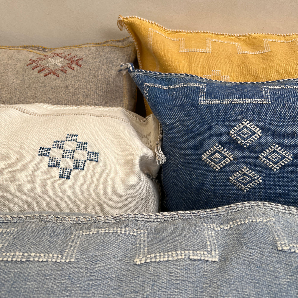 Collection of embroidered pillows in various colors and patterns.