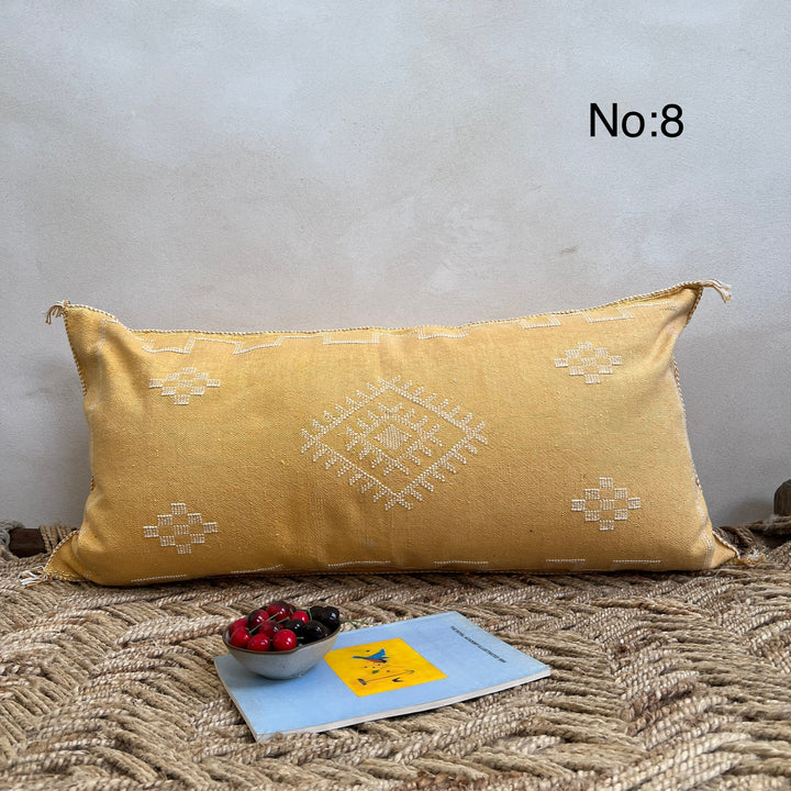 Yellow pillow with geometric patterns on a textured surface