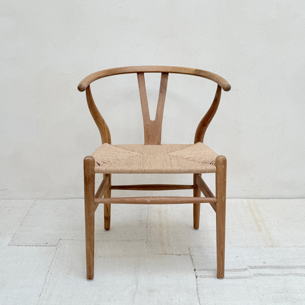 Wooden chair with woven seat on a white floor and background