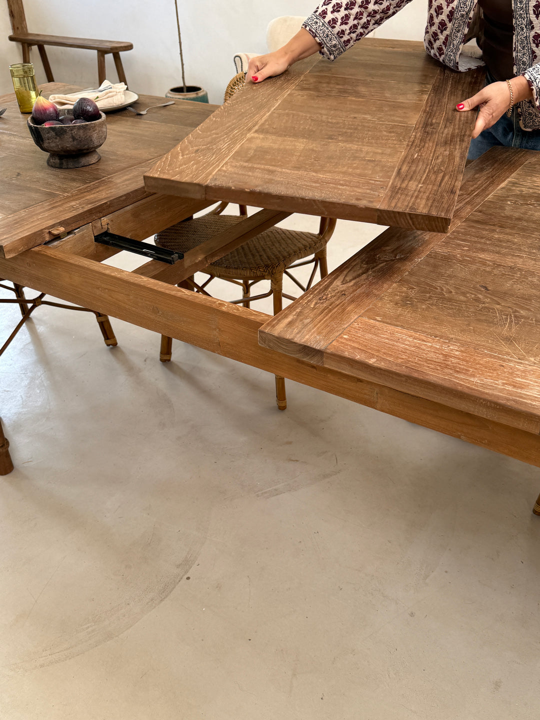 Close-up of the extending teak dining table revealing the integrated extension mechanism and beautifully crafted reclaimed teak top, designed to extend effortlessly for larger gatherings.