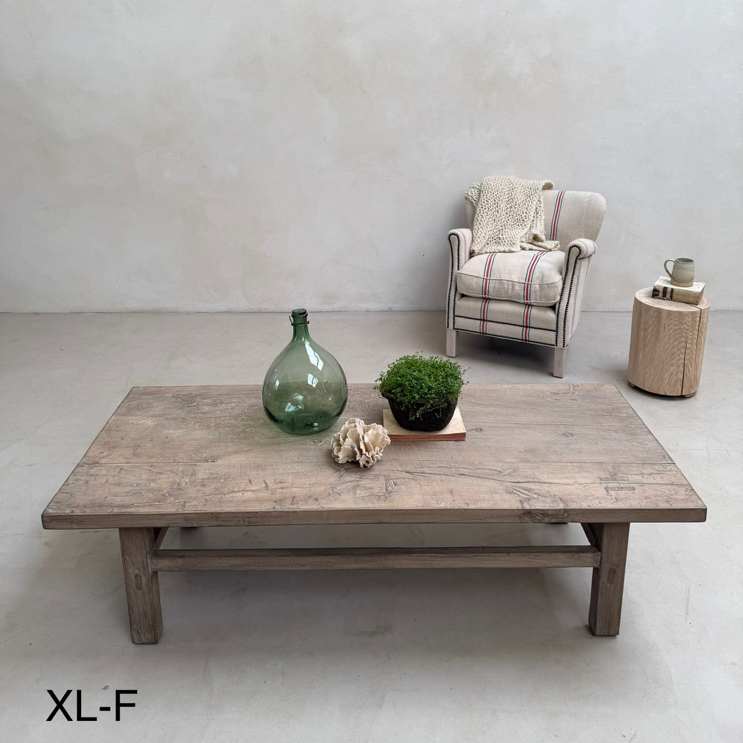 Wooden coffee table with decorative items in a minimalistic room.