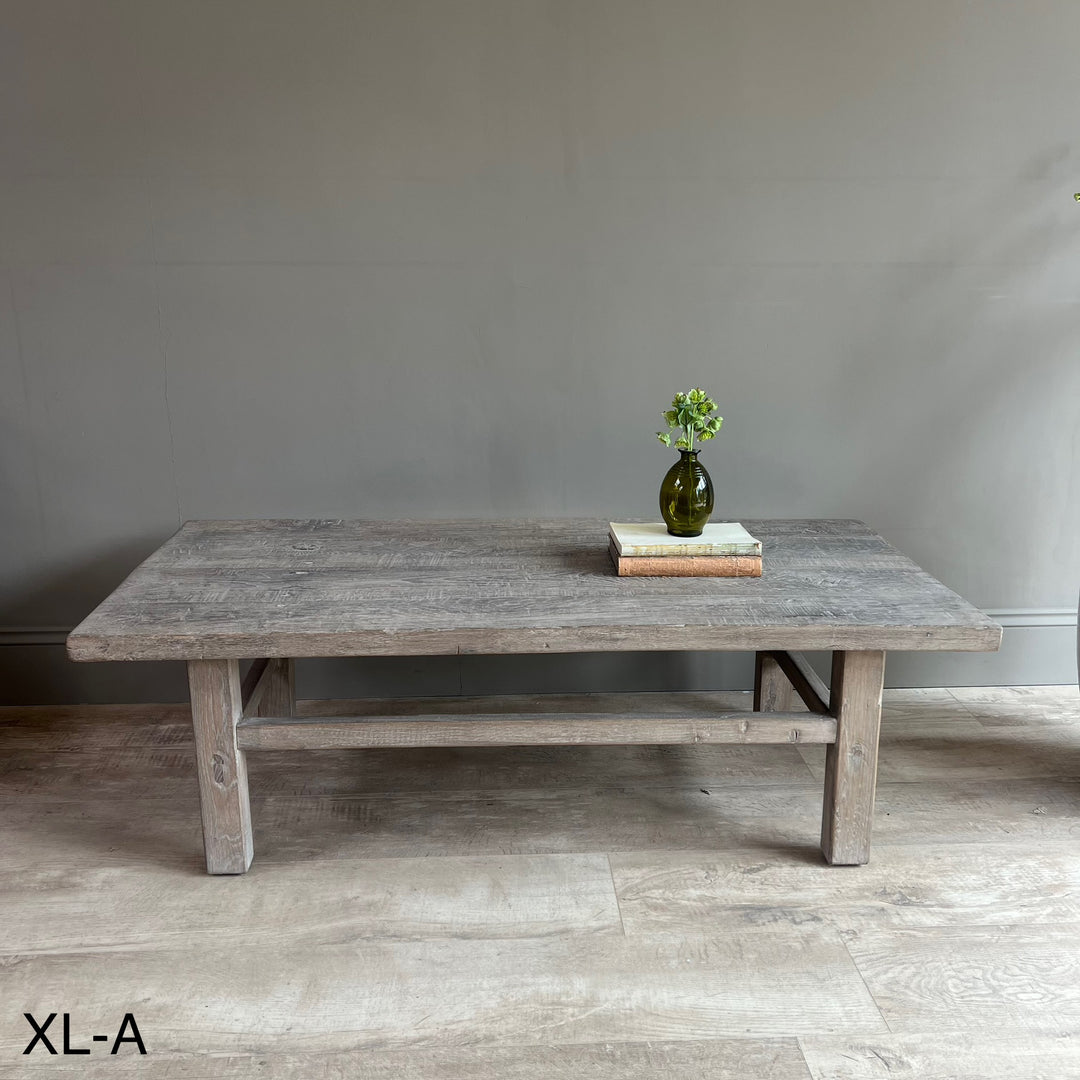 Wooden table with a vase and books on a gray wall background