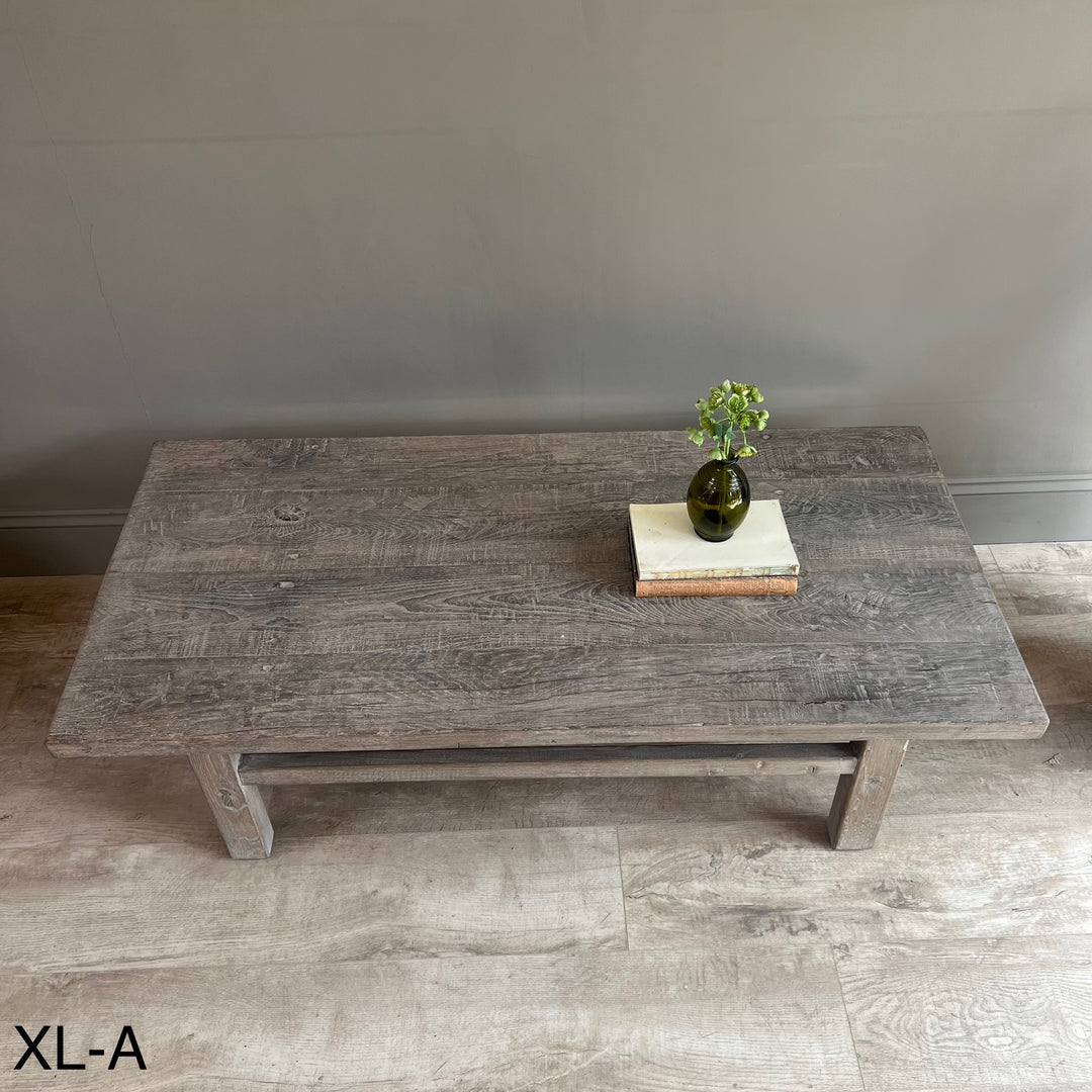 Wooden coffee table with decorative items on a gray floor and wall background