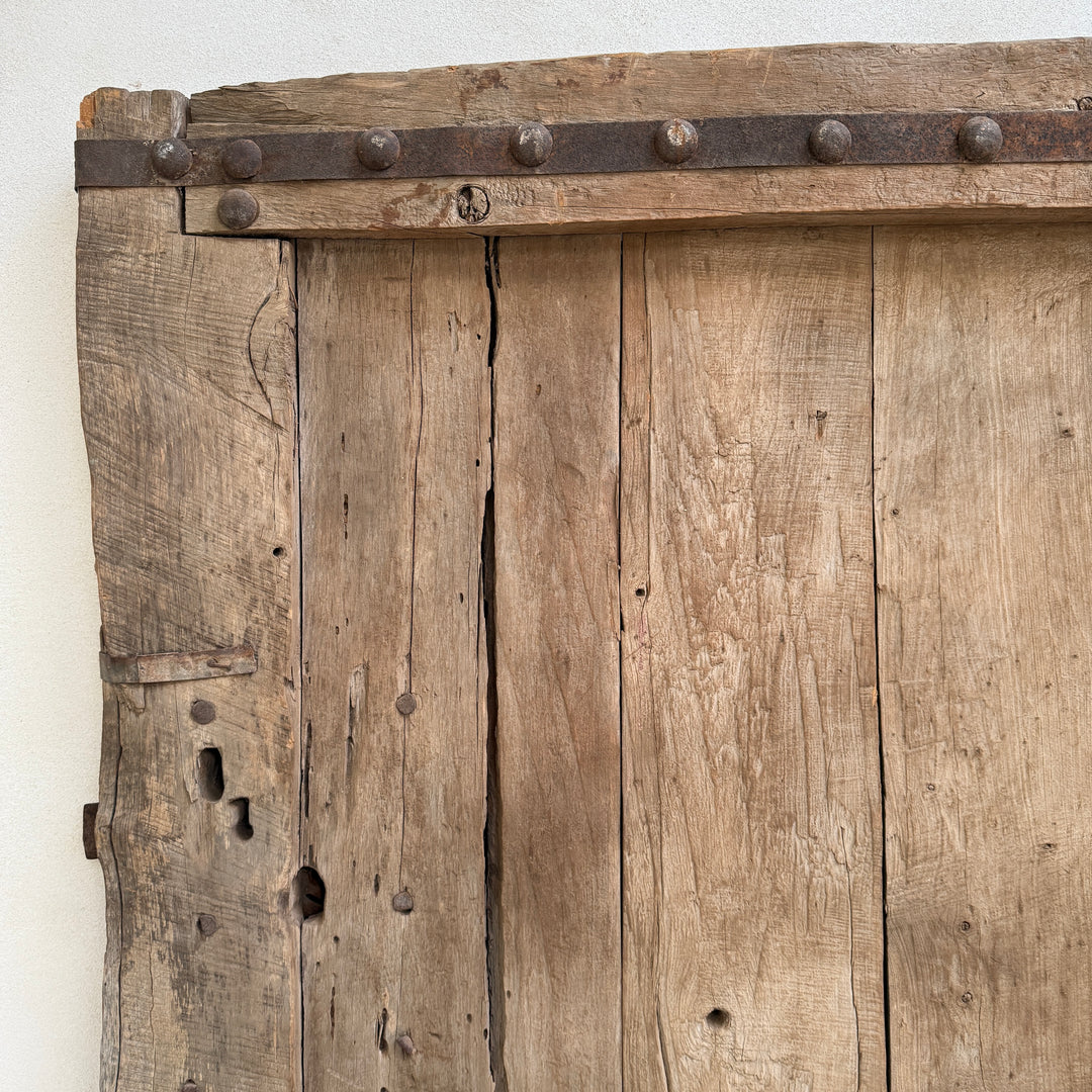 Close-up of an old wooden door with metal straps on a white background