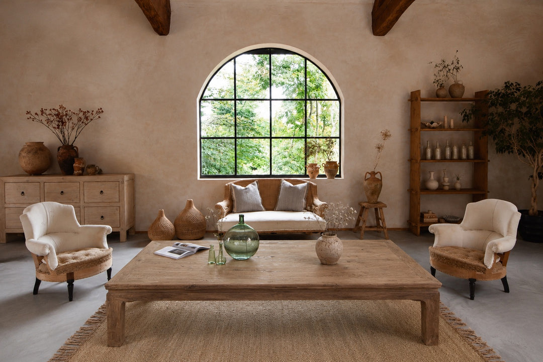 Living room with wooden coffee table, armchairs, and a large window.