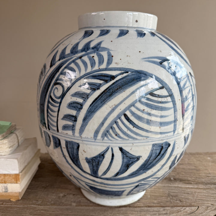Close up view of the hand-painted blue and white porcelain vase showcasing its bold botanical design and artisan-painted finish inspired by traditional Chinese porcelain.
