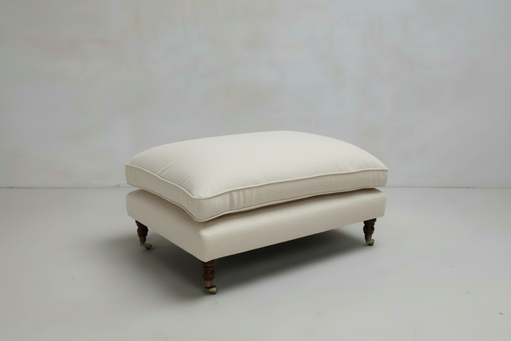 Beige ottoman with cushion on a white background