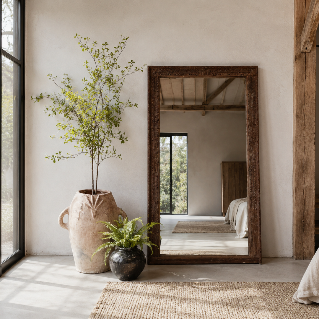 Antique full lenght antique mirror in a Modern bedroom with large mirror, plants, and wooden wardrobe.