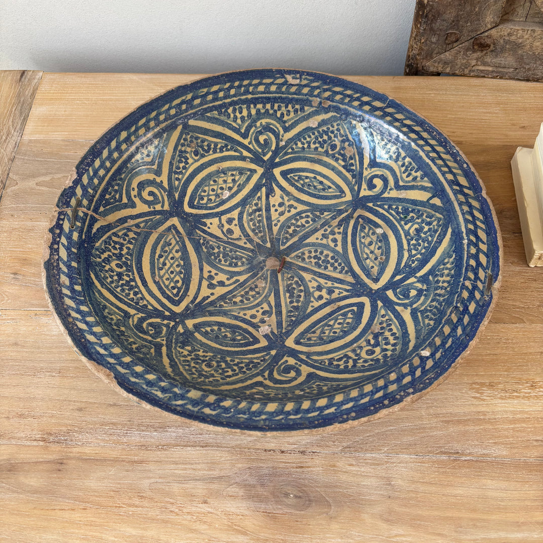 Decorative blue and beige ceramic bowl on a wooden surface