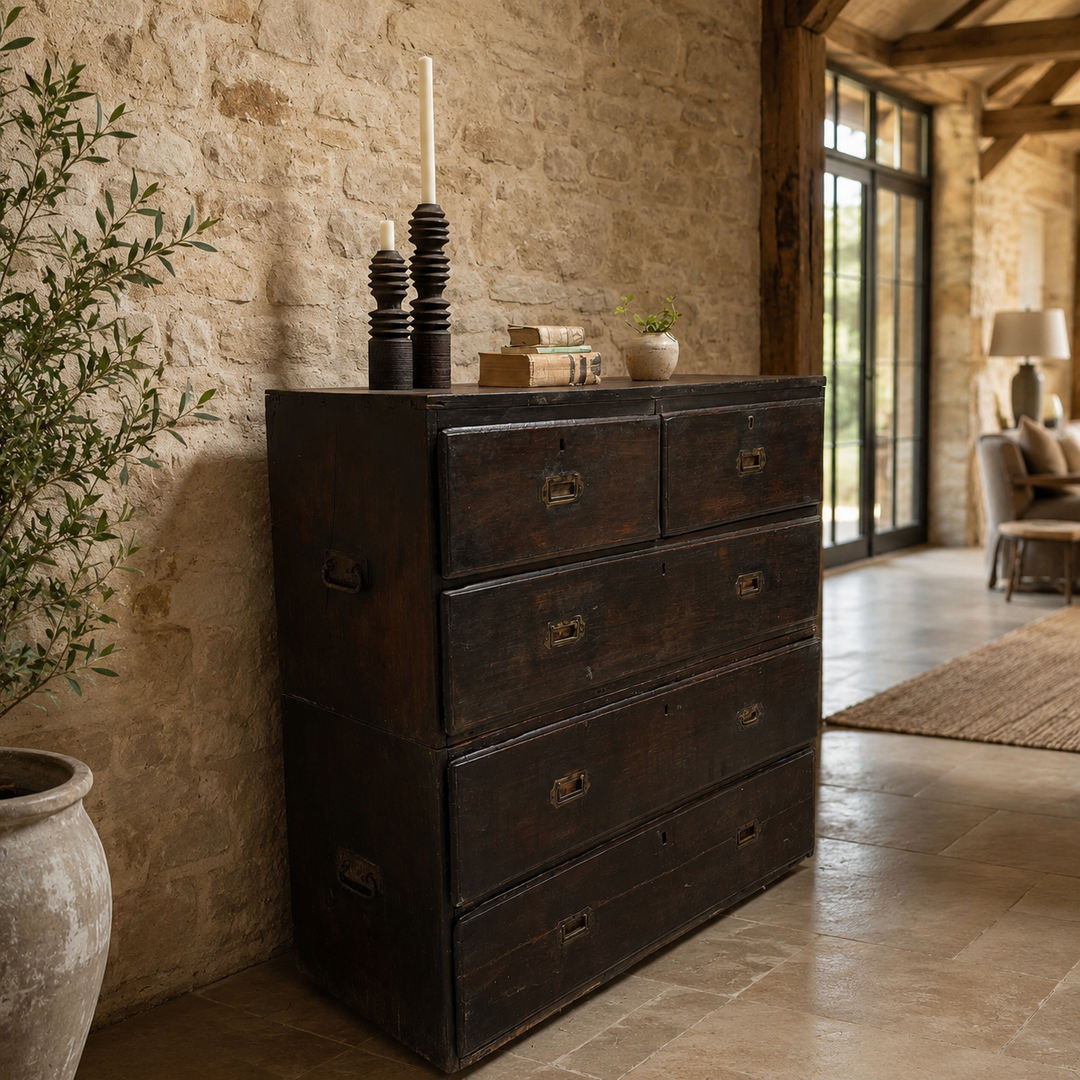 Dark wooden dresser against a stone wall in a rustic interior setting.
