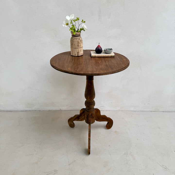 Front view of the Knepp solid teak round lamp table highlighting its turned pedestal base, handcrafted construction and timeless classic design.