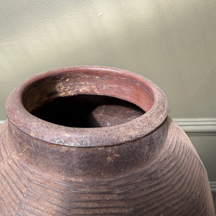 Detail of the opening and neck of an antique Chinese stoneware storage jar with naturally aged terracotta tones and handcrafted finish.
