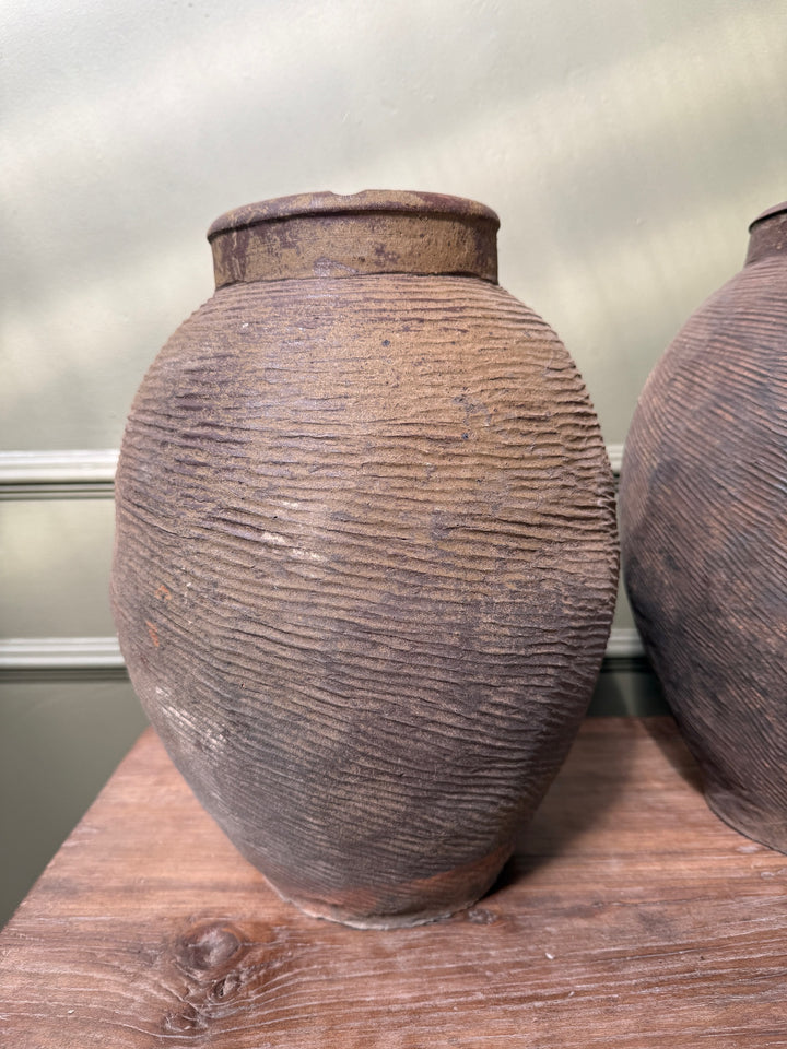 Front view of a large antique Chinese stoneware storage jar, handcrafted from iron-rich clay with a beautifully weathered surface.
