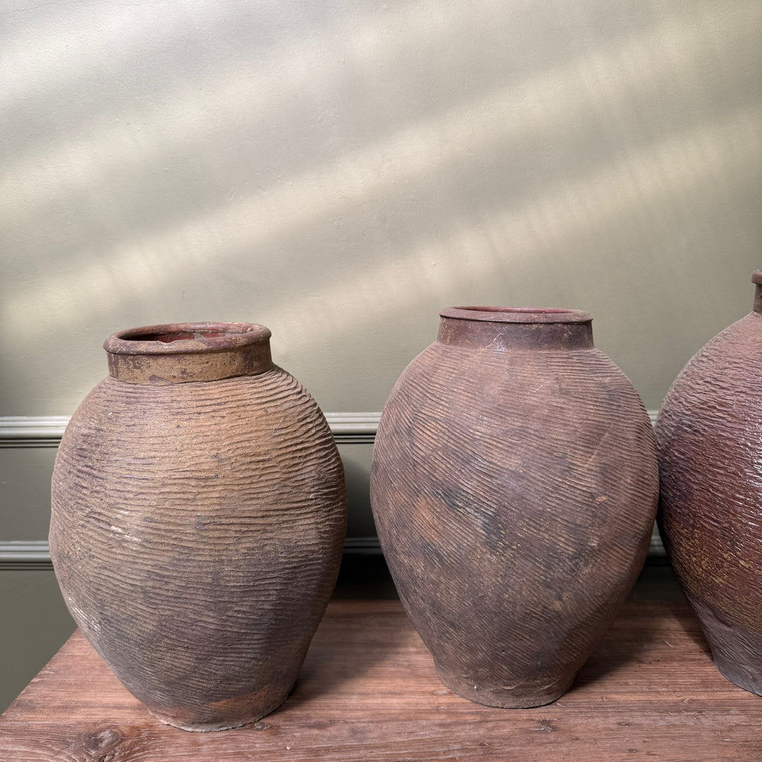 Pair of antique Chinese stoneware storage jars demonstrating the subtle variation in shape, colour and historic wear found in every piece.
