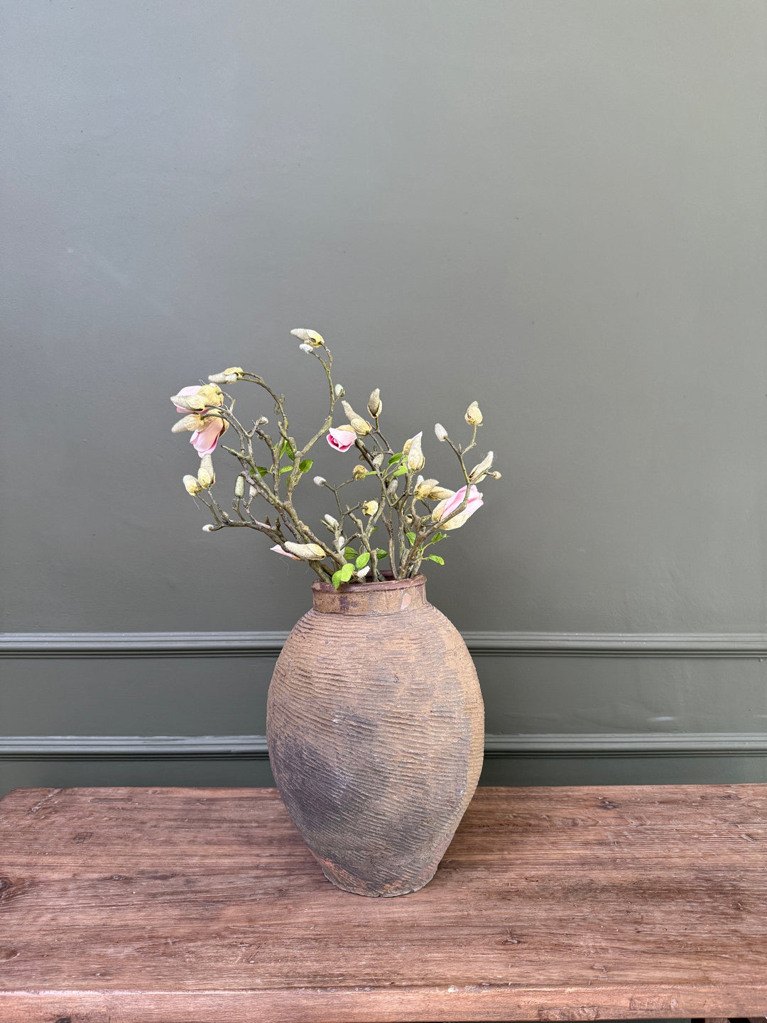 a large antique Chinese stoneware storage jar styled with flowering branches, demonstrating its sculptural form and beautifully aged character.