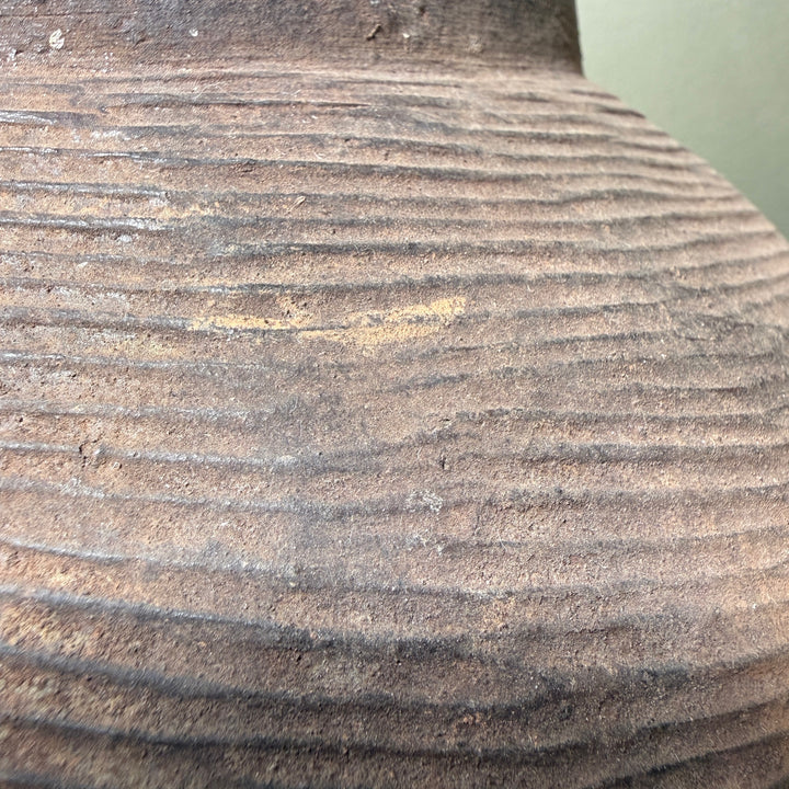 Close-up of the naturally weathered stoneware surface with traditional combed decoration and rich iron clay tones.
